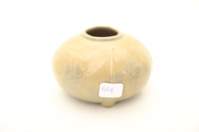 un petit vase muni d'une étiquette, posé sur une table