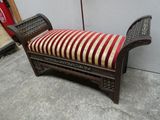 un banc sur lequel est posé un coussin rayé, devant un mur