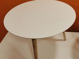 a white table with a wooden legs on a white surface