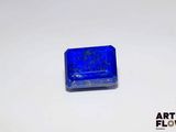 un petit objet bleu de forme carrée posé sur une surface blanche