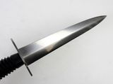 someone is holding a knife with a black handle on a white surface