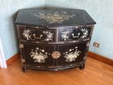 une commode noire et dorée dans une pièce