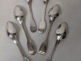 six silver spoons are arranged in a circle on a white surface