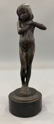 statue en bronze d'un garçon tenant une batte de baseball, posée sur un socle