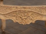 a wooden bench with carvings on it on a brick floor