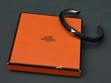 an orange box with a black bracelet on it sitting on a table