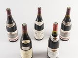 six bottles of wine are arranged in a circle on a white surface