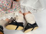 two dolls sitting next to each other on a white surface