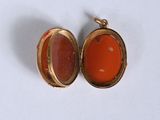 an image of a gold locke with a carnel stone in it