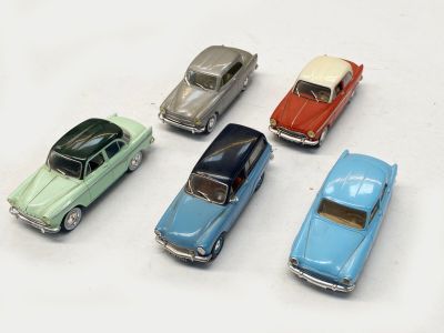 plusieurs petites voitures sont alignées sur une surface blanche