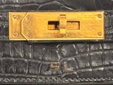 an image of a close up of a black purse with a gold buckle