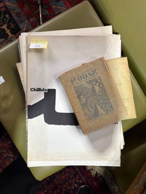 une pile de papiers posée sur une chaise verte