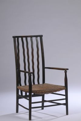 une image représentant une chaise avec une assise tressée posée sur une surface blanche