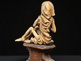 an image of a statue of a woman sitting on top of a wooden block
