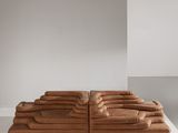 un canapé en cuir marron posé sur une table blanche
