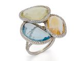 un gros plan d'une bague ornée de trois pierres de couleurs différentes