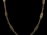 un collier à chaîne en or avec un maillon allongé sur fond noir