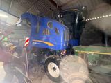 a blue tractor that is parked inside of a building
