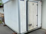 un grand conteneur blanc posé à l'extérieur d'un bâtiment