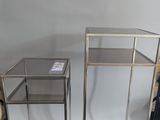 pair of metal and glass side tables on wheels