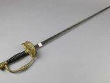 a close up of a sword on a table with a white background