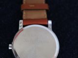 a close up of a watch sitting on a black surface