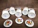 six cups with fruit designs on them sitting on a table