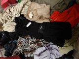 une valise pleine de vêtements et des vêtements par terre
