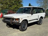 un Land Rover blanc garé sur un parking