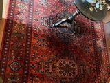 un tapis posé à même le sol, sur lequel est posé un vase de fleurs