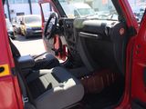 a red jeep with the door open in a parking lot