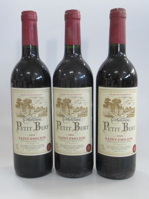 three bottles of red wine sitting on top of a white table