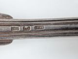 an antique silver plate with a spoon and spoon rest on it