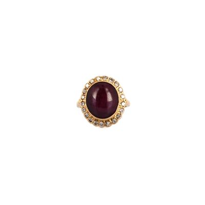 a close up of a gold ring with a red stone