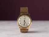 une montre-bracelet en or posée sur une surface en marbre