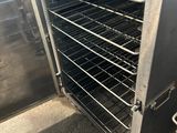 un grand four métallique contenant de nombreuses grilles remplies d'aliments