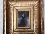 an old picture of a woman in a black dress in a gold frame
