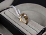 une bague en or dans un étui noir, attachée à un cordon blanc