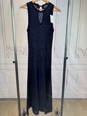 black beaded dress hanging on a clothes rack in a room