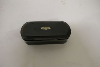 une petite boîte noire ornée d'un emblème doré