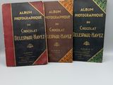 three books are lined up on top of each other on a white surface