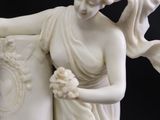 a statue of a woman holding a vase with flowers on it