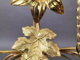 a gold vase with flowers and leaves on it