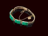 bracelet doré et vert sur fond noir, orné d'une breloque en forme de cœur