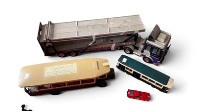 trois camions miniatures et un bus posés sur une surface blanche