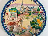 une assiette décorative sur laquelle est représentée une ville