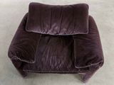 a purple chair with a pillow on it in a room