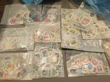 many bags of stamps on a table with a blue bag