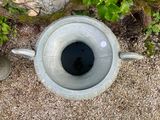 a concrete urn with a hole in the middle of it