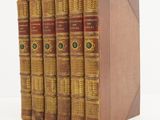 a set of five books sitting on top of each other on a white surface